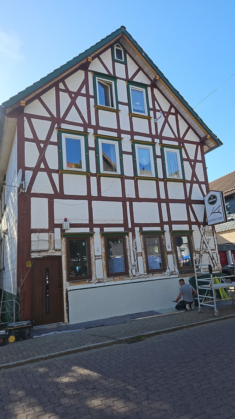 Saniertes Fachwerkhaus mit rotem Fachwerk und hellem Putz an einer Dorfstraße